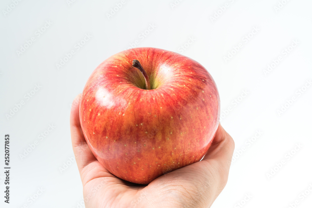 Holding an apple in the hand from below isolated on white background