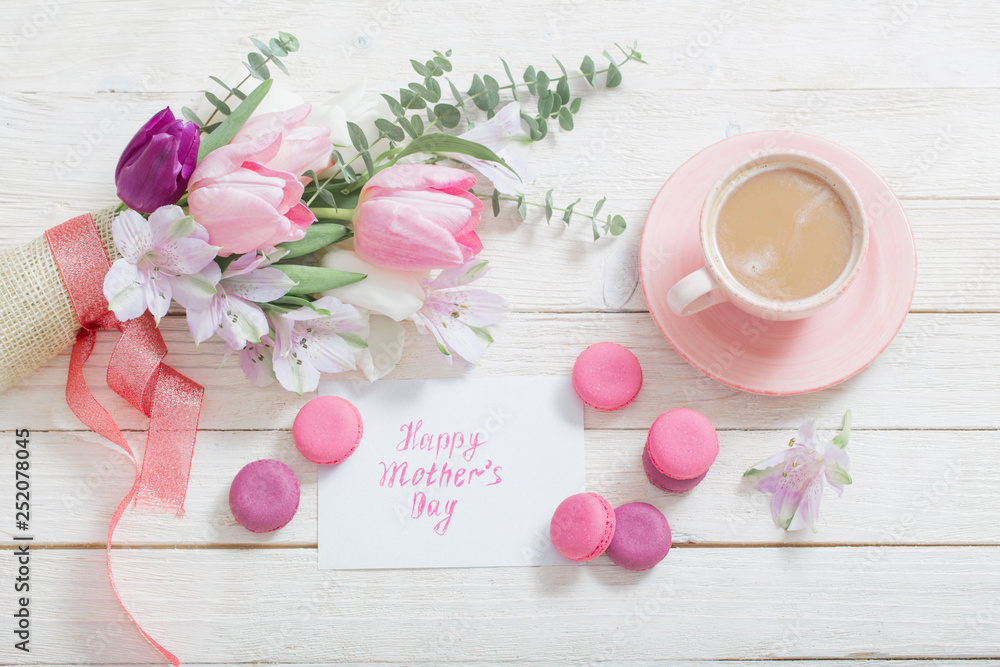 Tulips and cup of coffee with dessert on white background. Concept mother's day top view Tulips and cup of coffee with dessert on white background. Concept mother's day top view