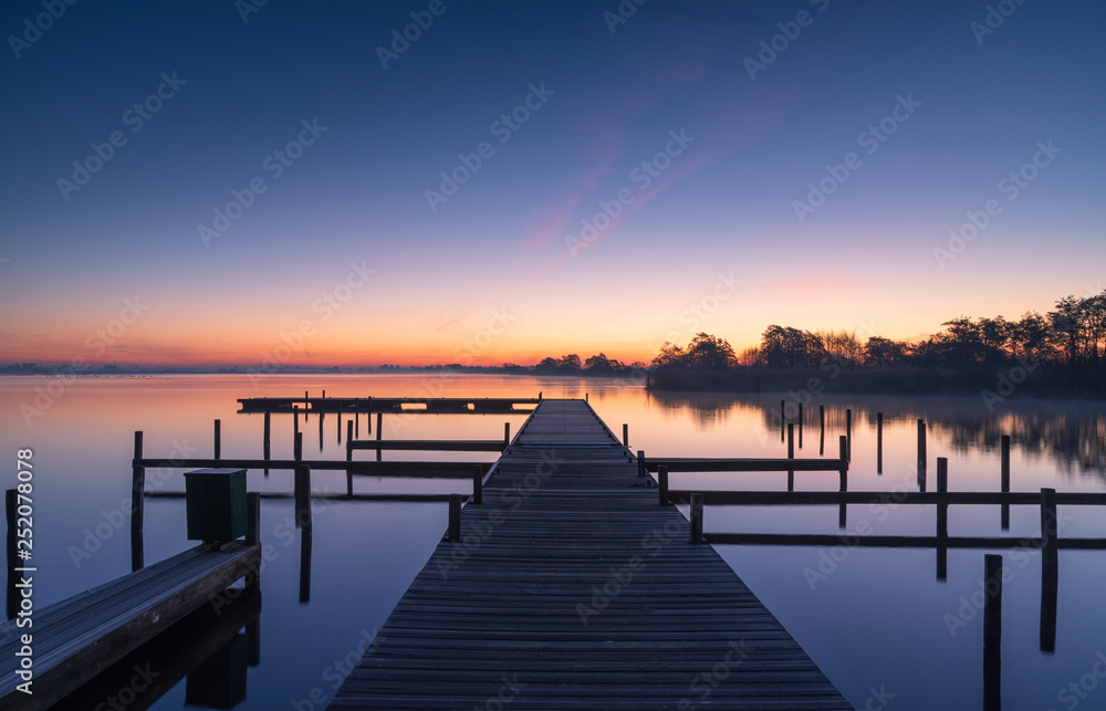 Tranquil dawn at a jetty at the Leekstermeer, in Holland.