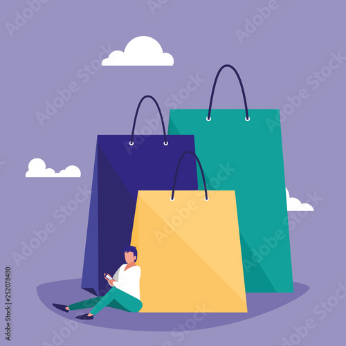 young man using smartphone with shopping bag