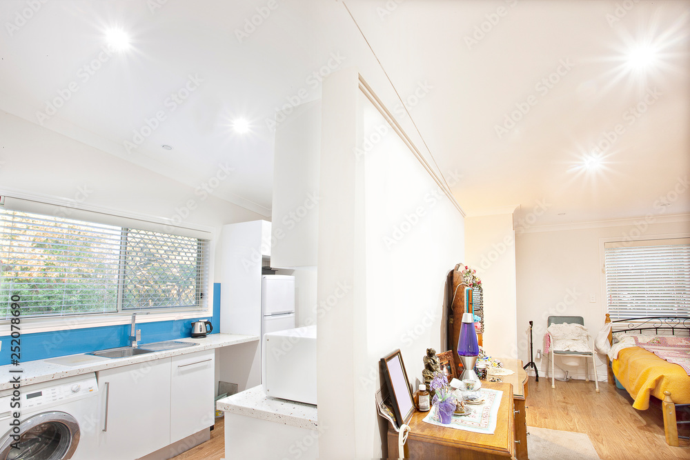 Fototapeta premium Open plan apartment with view of kitchen and bed