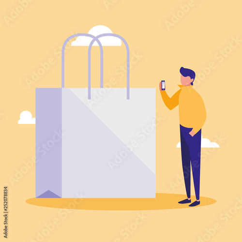 young man using smartphone with shopping bag