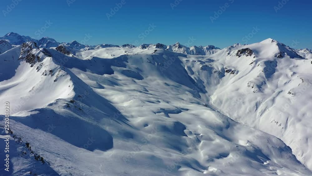 Aerial panoramic view of Alps, landscape panorama of snowy mountain range in winter, sunny day with blue sky - Alps from above, ski resort Livigno, Italy, Europe Aerial panoramic view of Alps, landscape panorama of snowy mountain range in winter, sunny day with blue sky - Alps from above, ski resort Livigno, Italy, Europe