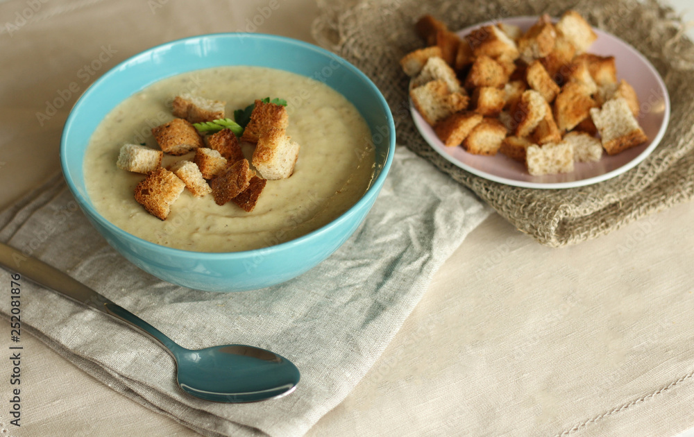 homemade mushroom soup with croutons in a blue plate. photo in light colors. rustic style homemade mushroom soup with croutons in a blue plate. photo in light colors. rustic style