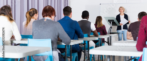 Students working with professor in auditorium