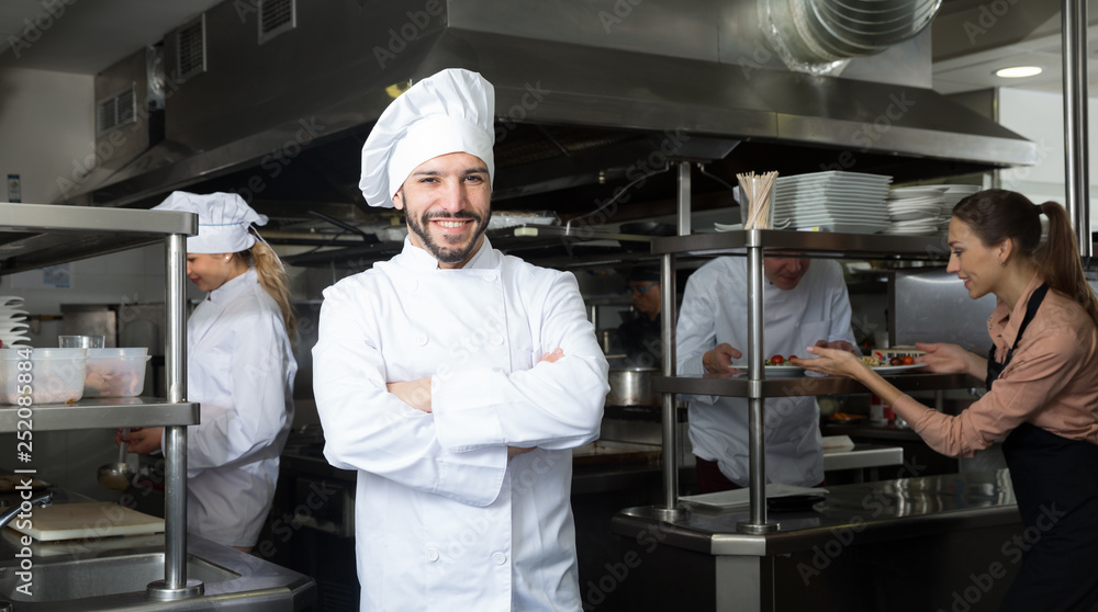 Chef in kitchen with working staff