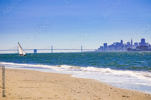 Sailing ship as seen from Angel Island; on the background the Bay Bridge and Alcatraz Island and the Financial District skyline, San Francisco bay, California