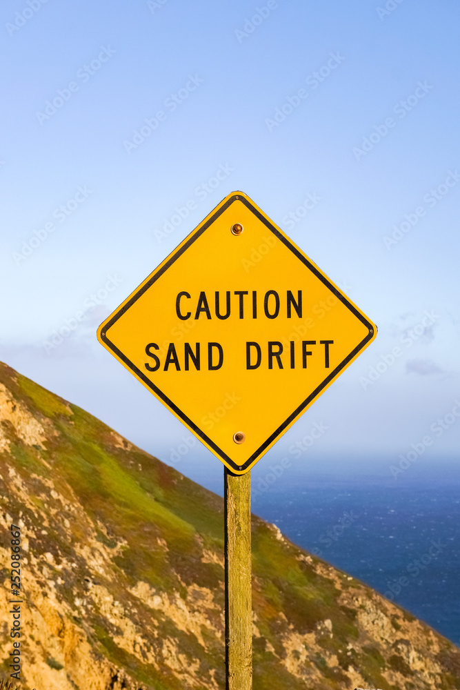 Sand drift sign on the Pacific Ocean coast, California Sand drift sign on the Pacific Ocean coast, California