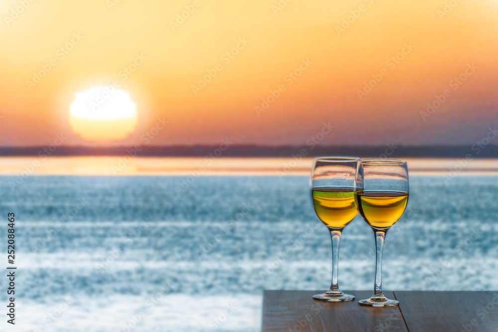 Two glasses of White Wine Overlooking the sea during the sunset