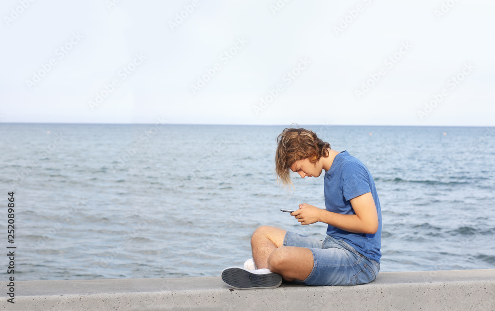 Teenage boy typing text message.Using smart phone.