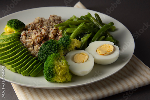Salad bowl with quinoa and green vegetables - green peas, avocado, broccoli and eggs. Healthy food, green salad palte.