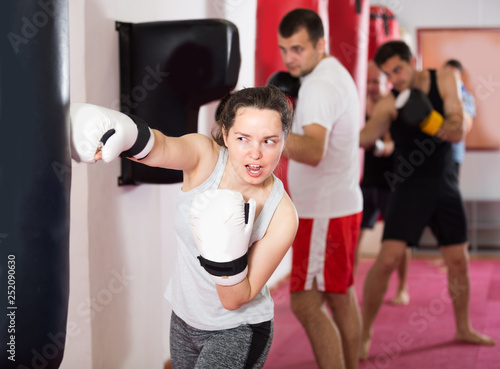 Athlete woman is beating a boxing bag