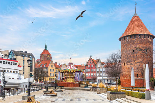 Swan Tower, the Dome of the Church and the carrousel on the bank of the Motlawa in Gdansk, Poland