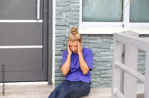Portrait of depressed woman sitting on stairs at home.Crying woman