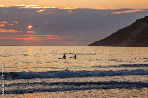 sunset on Unstad beach surrounded by mountains in Lofoten in Norway