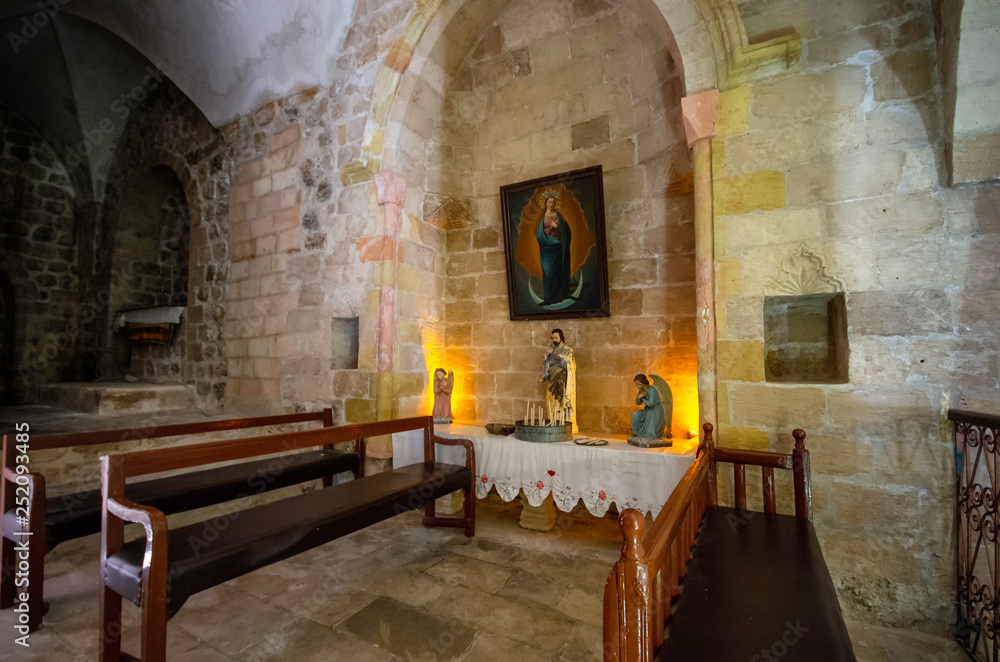 Mardin / Turkey - May 16 / 2015 :  Interior view of Saint Hirmiz Chaldean church with Jesus statue and candles