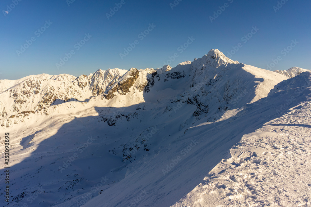 Big snow-capped peaks of the Tatra Mountains on a sunny day.