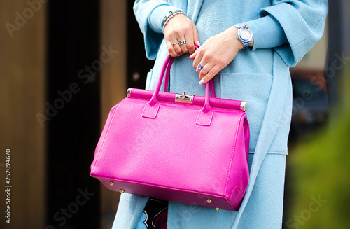 Pink leather bag in female hands. Stylish modern and feminine image, style. Bag close up.