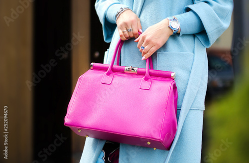 Pink leather bag in female hands. Stylish modern and feminine image, style.  Bag close up.