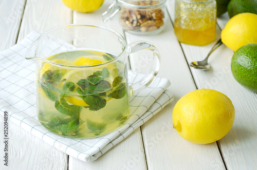 healthy drink with lemon, mint and honey on white table