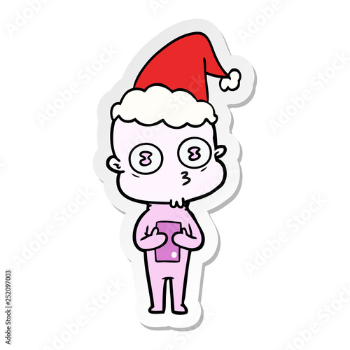 sticker cartoon of a weird bald spaceman wearing santa hat