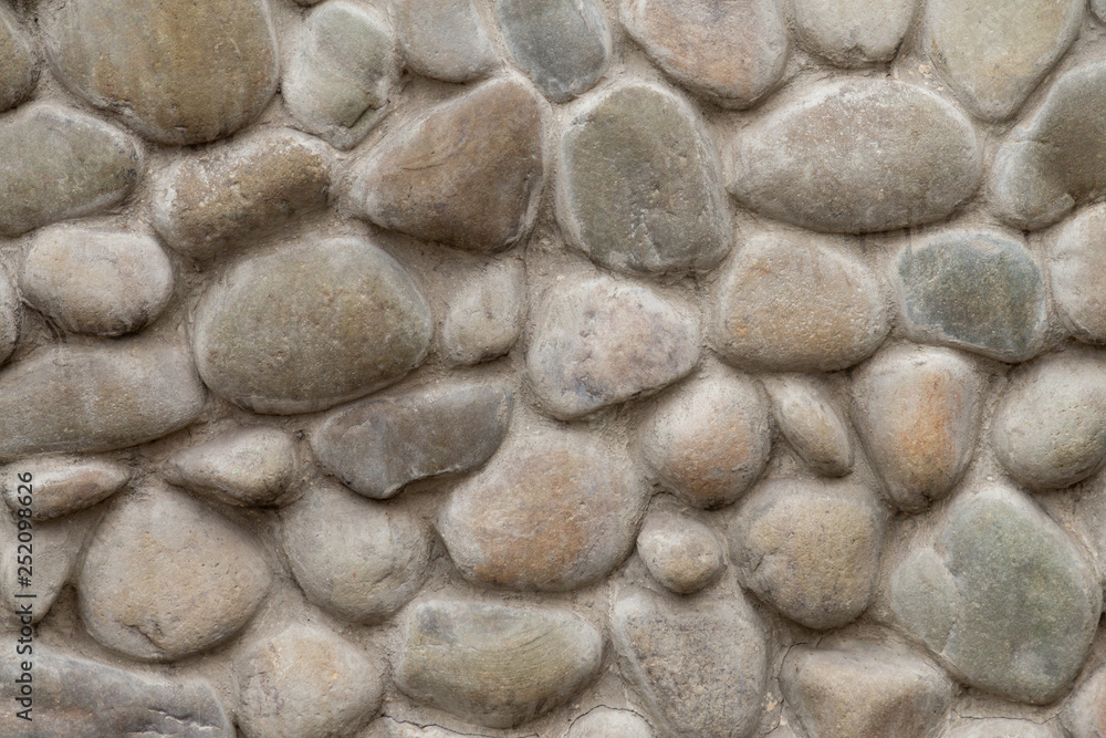 Brown stone wall of pebbles, background, texture Brown stone wall of pebbles, background, texture