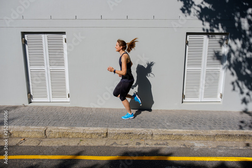 female sprinter running along a road