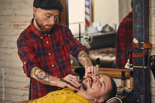 Client during beard shaving in barber shop © nazarovsergey