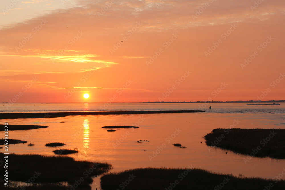 beautiful sunset at the coast with an orange sky and orange water beautiful sunset at the coast with an orange sky and orange water