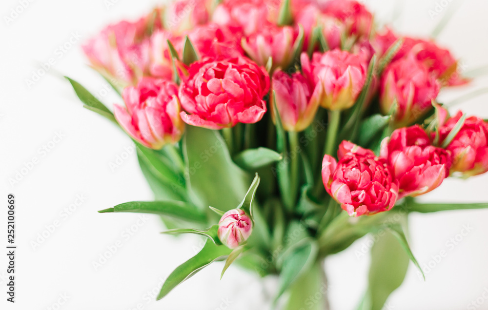 A bouquet of pink red white peony tulips in a gray modern vase on wooden tabel A bouquet of pink red white peony tulips in a gray modern vase on wooden tabel