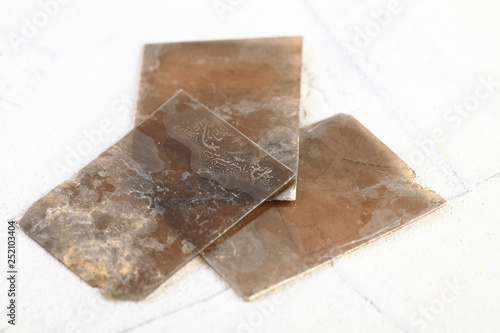 Natural mineral from geological collection - rough muscovite mica, common mica on white cement background from Poldnevoe, Ural, Russia.