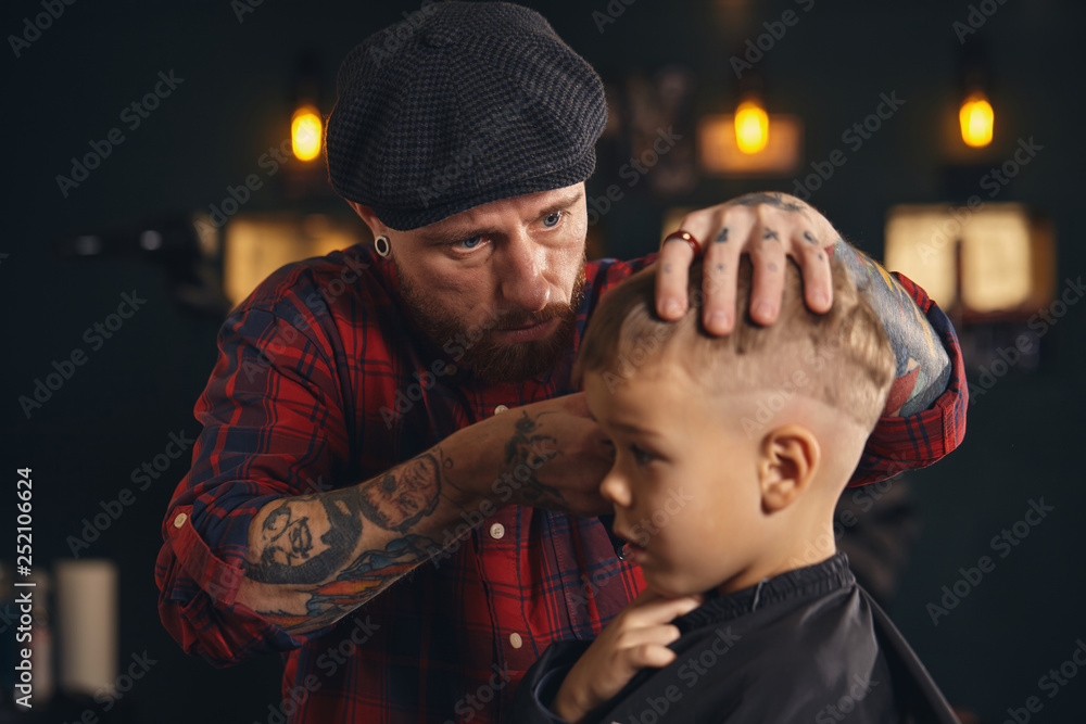 Caucasian boy getting haircut in barbershop indoor Caucasian boy getting haircut in barbershop indoor