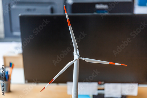 Close-up of wind turbine model and desktop computer in office photo