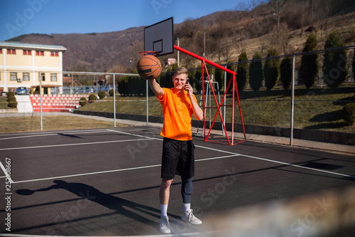 Young basketball player using phone