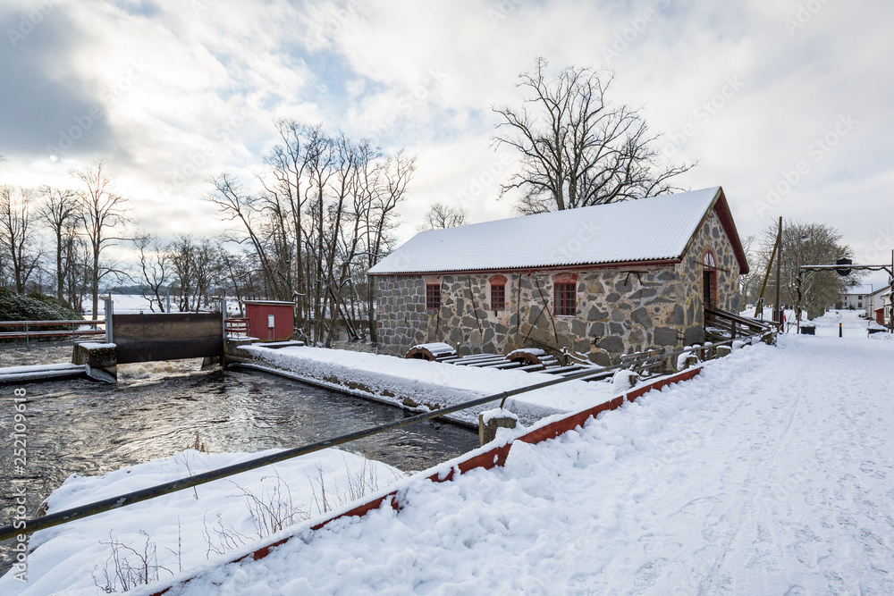 Winter scenery with river mill in Sweden