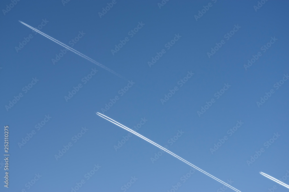 Blick nach oben in den strahlend blauen und wolkenlosen Himmel mit 3 Flugzeugen mit Kondensstreifen die parallel und versetzt in die gleiche Richtung fliegen Blick nach oben in den strahlend blauen und wolkenlosen Himmel mit 3 Flugzeugen mit Kondensstreifen die parallel und versetzt in die gleiche Richtung fliegen