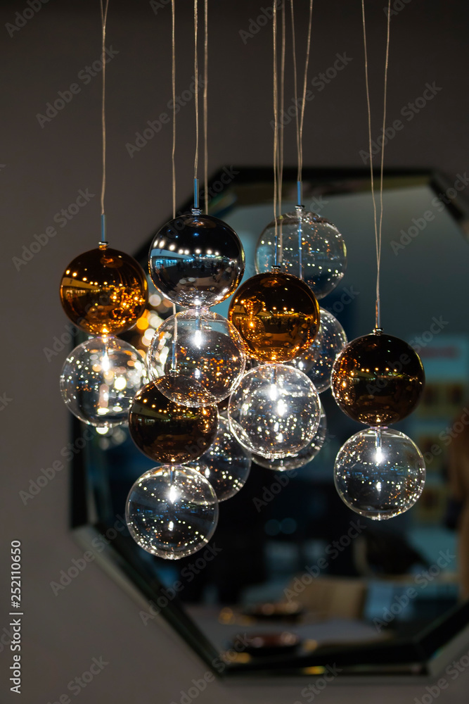 Lighting balls on the chandelier in the lamplight, light bulbs hanging from the ceiling, lamps on the dark background Lighting balls on the chandelier in the lamplight, light bulbs hanging from the ceiling, lamps on the dark background