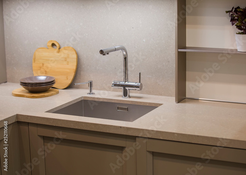 Kitchen faucet  modern gray kitchen in loft style  gray table  luxury faucet kitchen