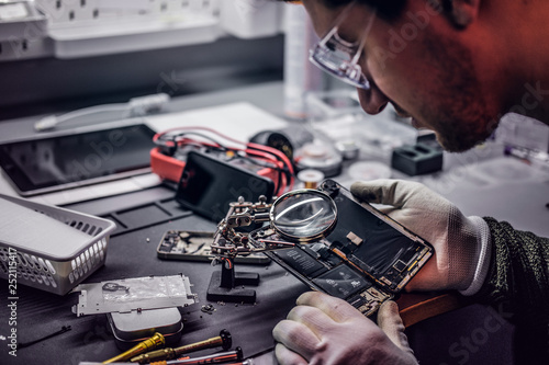 Εκτύπωση καμβά The technician uses a magnifying glass to carefully inspect the internal parts o