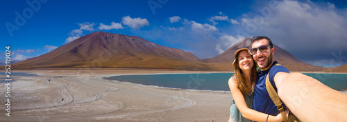 Happy couple tourists backpacker taking selfie in Laguna Verde, the salt lake at the foot of the volcanos Licancabur and Juriques. Eduardo Avaroa Andean Fauna National Reserve, Bolivia. South America photo