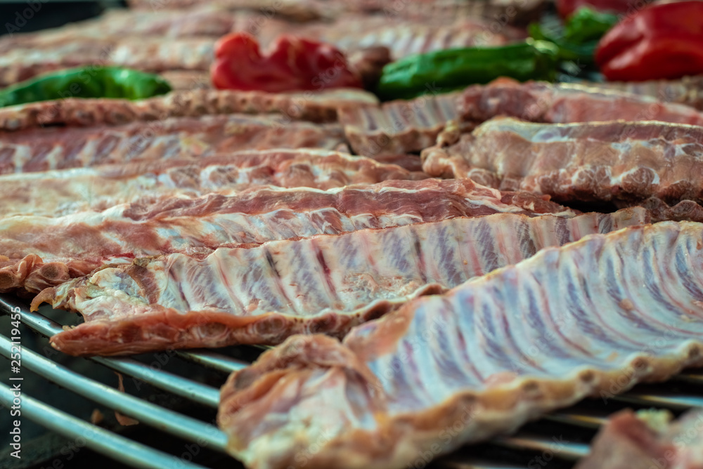 Raw pork ribs on a grill on a barbecue.