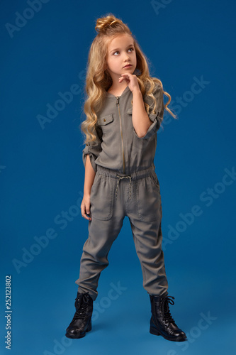 Little girl with a long curly hair in a fashionable clothes photo