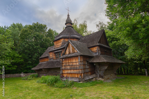Old wooden church among dense foliage in the open-air museum Pirogovo Kiev