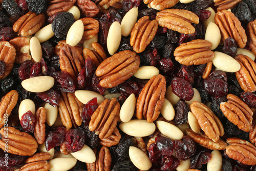 Mix of pecan nuts, black raisins jumbo, cranberries, almonds without peel. Background. Closeup.