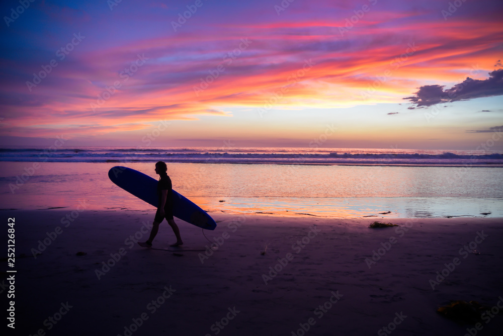 Silhouette of a surfer at sunset
