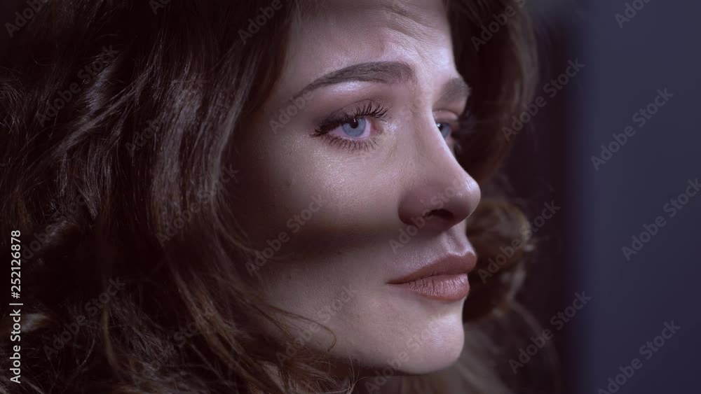 Sad pensive young woman crying alone in the dark- close up Sad pensive young woman crying alone in the dark- close up