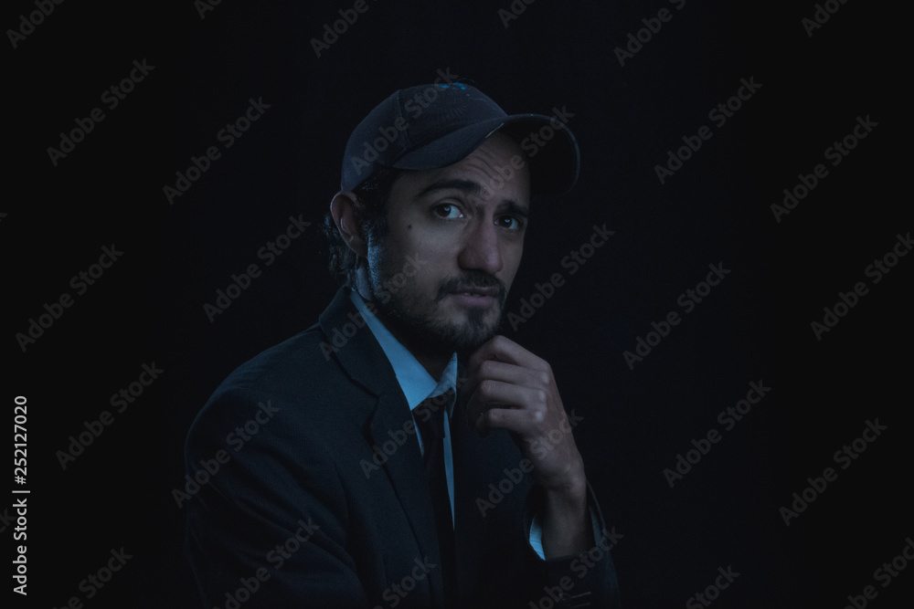 portrait with black background of a young man with cap and shirt and tie portrait with black background of a young man with cap and shirt and tie