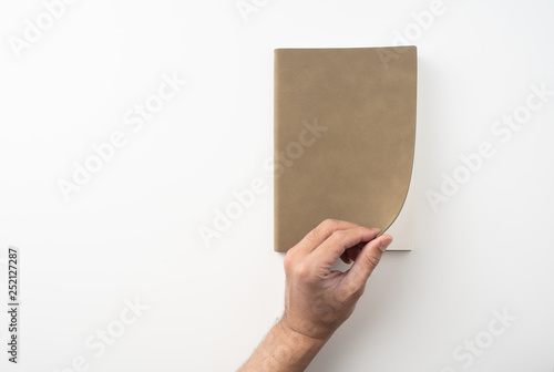 Fototapeta Naklejka Na Ścianę i Meble -  man hand hold brown notebook on white background