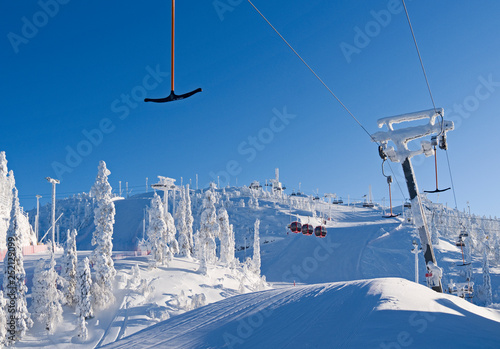 Kuusamo / Finland: T-bar lift, gondola and chairlift in the Ruka ski area on a beautiful and sunny day in February photo