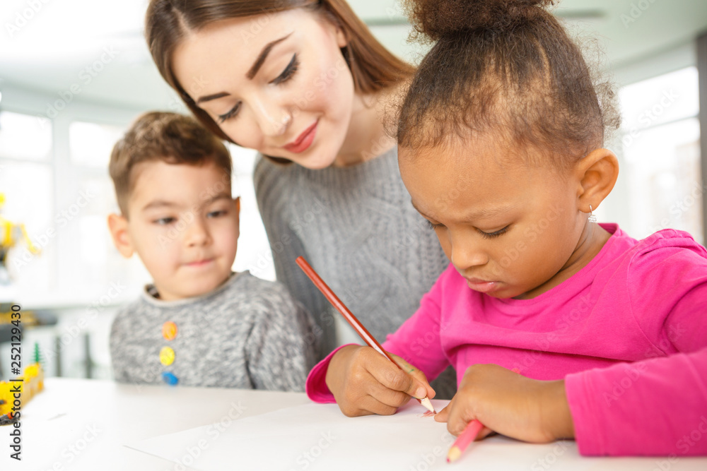 Attractive young teacher with her young students at elementary school Attractive young teacher with her young students at elementary school